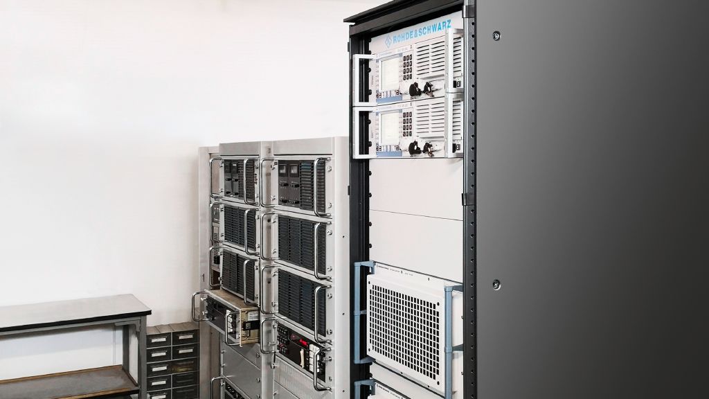 New versus old: 1 kW transmission power requires a certain amount of space even with modern technology (front), especially if the components are redundant for safety reasons. The old system (back) took up two racks.