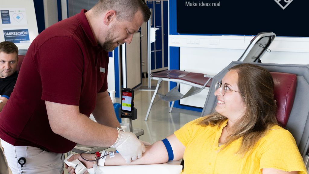 R&S-Mitarbeiterin Katrin Mühlbauer bei ihrer Blutspende durch Andreas Hofpointner vom BRK.