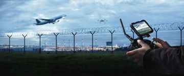 Drone and drone pilot with remote control at an airport